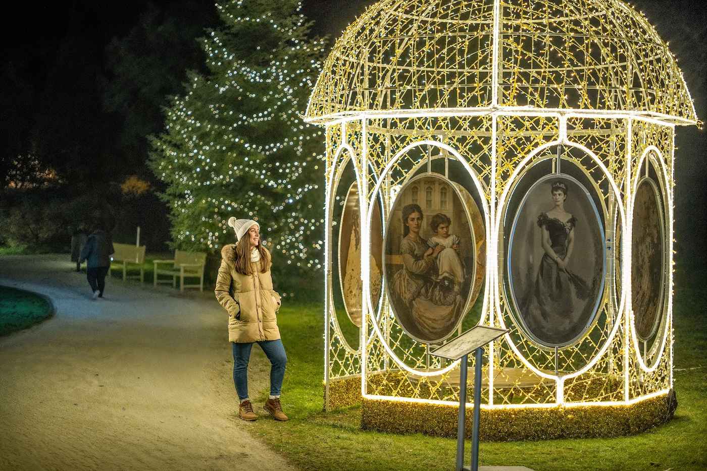 A domed light pavilion with painted portraits of Empress Elisabeth inside, a visitor standing in front