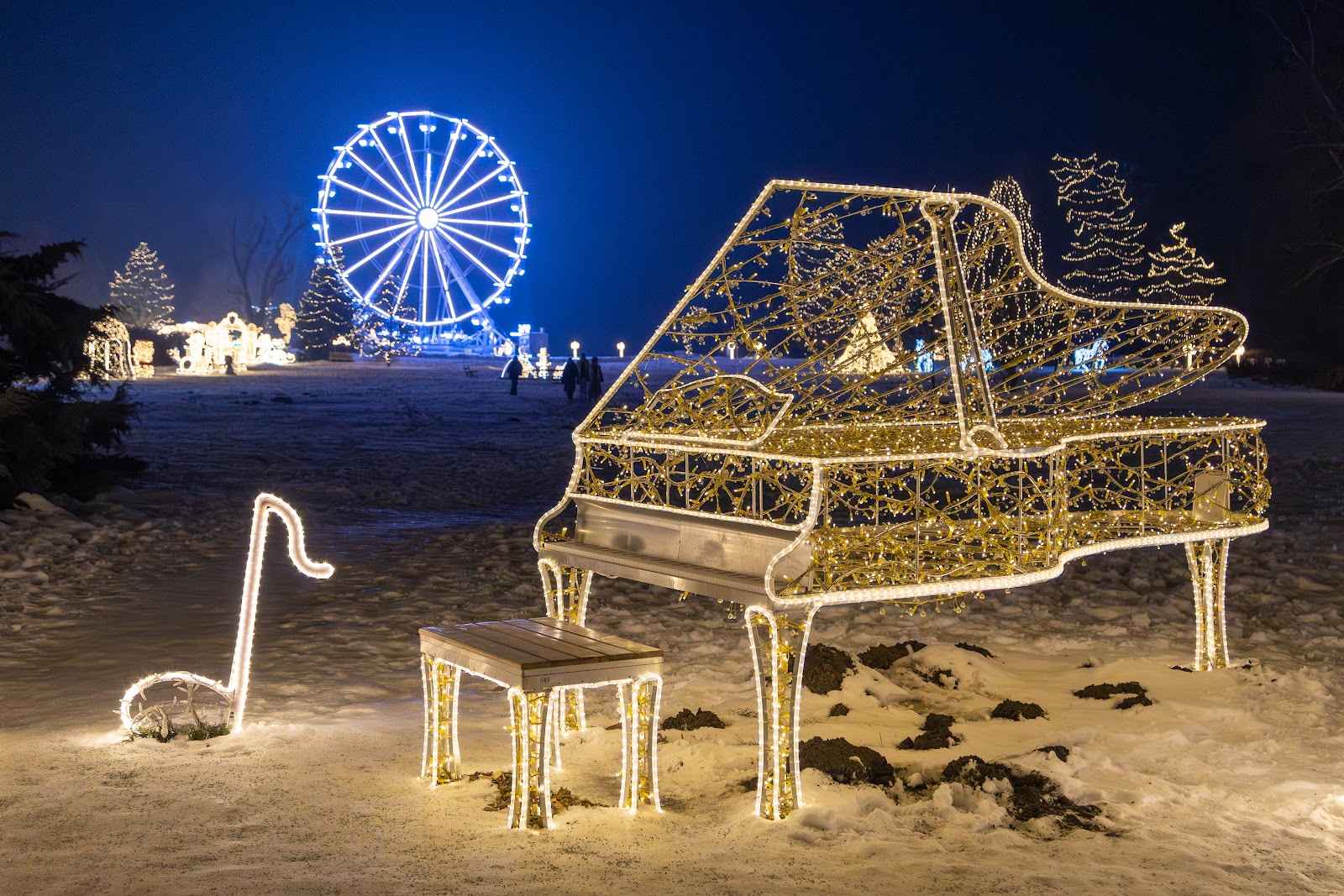 A grand piano rendered in warm light with musical notes beside it, a blue ferris wheel in the background